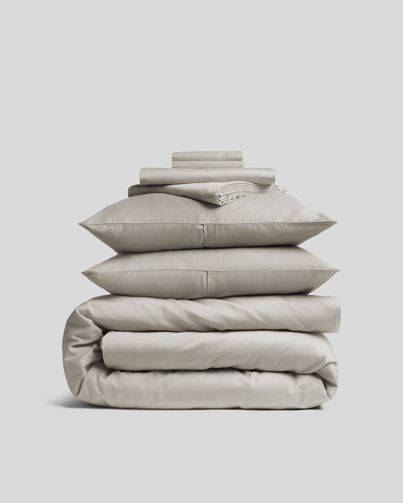 Luxurious sateen bedding bundle, white, top view.