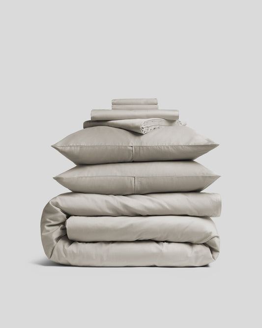 Luxurious sateen bedding bundle, white, top view.