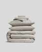 Luxurious sateen bedding bundle, white, top view.